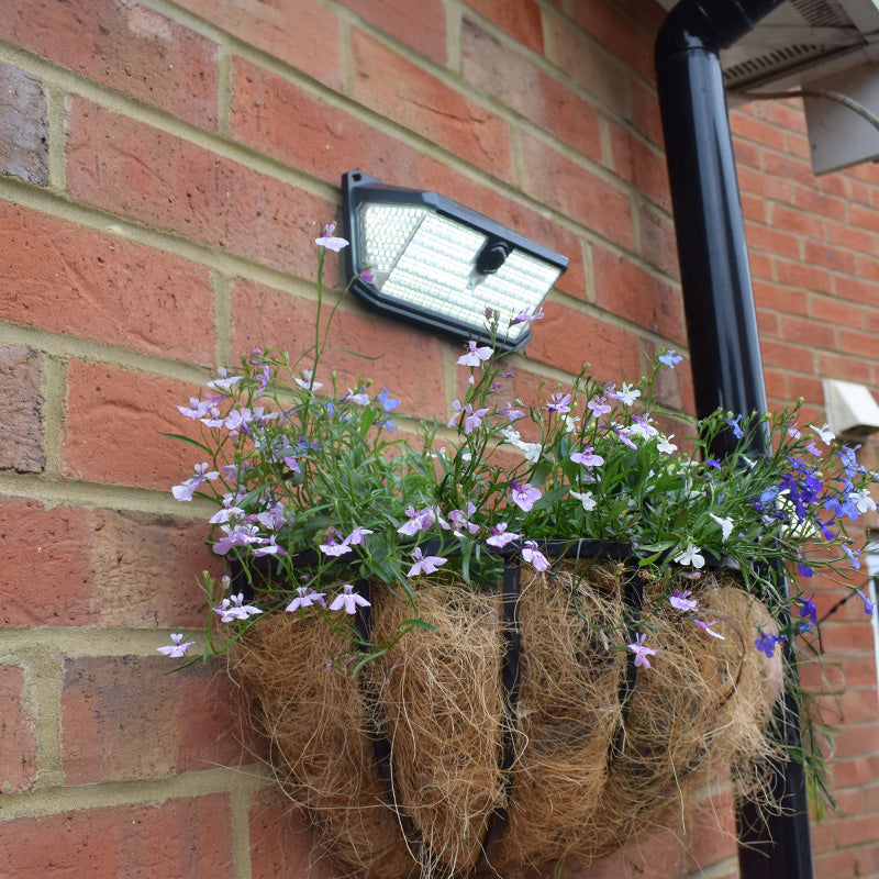 Alerta solar wall light installed above a hanging basket