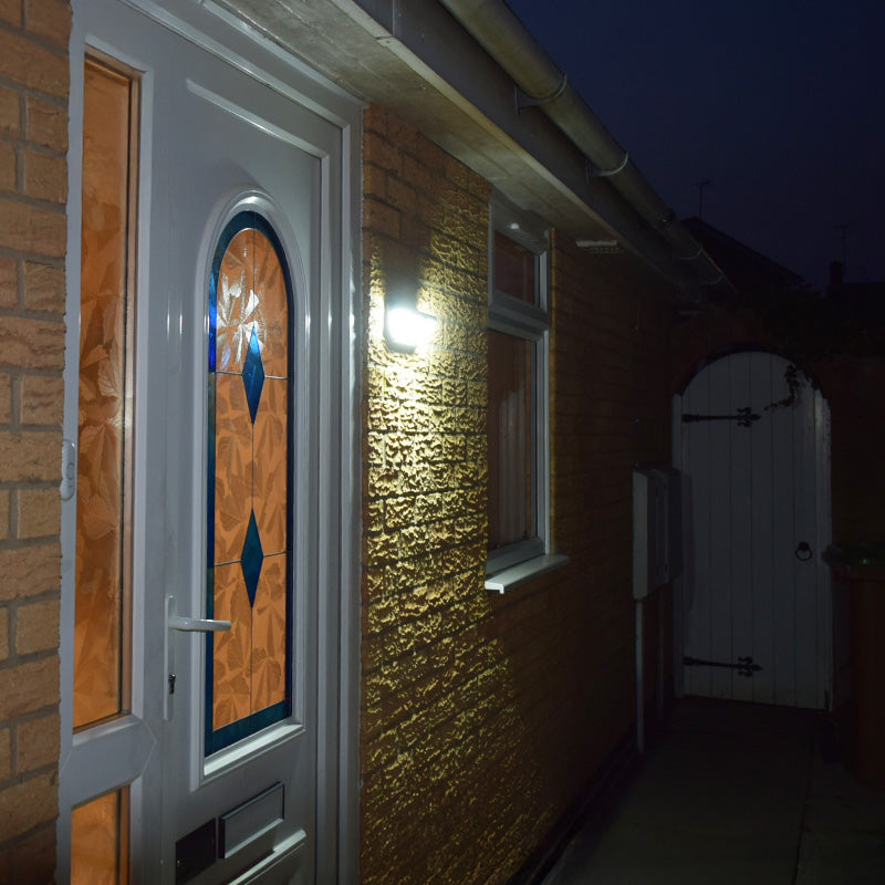 Alerta solar security light illuminating a doorway and side path